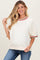 woman wearing a cream maternity sweatshirt with red and green striped details and a visible baby bump