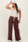 woman wearing a beige short sleeve maternity top and brown wide-leg maternity sweatpants with side stripes