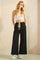 woman wearing a black wide-leg pants with an elastic waistband and a white cropped tank top