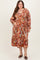 woman wearing a colorful floral print maternity dress with long sleeves and a v-neckline, showcasing her baby bump