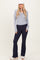 woman wearing a gray long sleeve henley top and navy flared workout pants with a white cap and sneakers