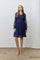 woman wearing a navy blue lace long sleeve dress with a v-neck and a flared skirt