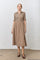 woman wearing a brown and beige checkered midi dress with short puff sleeves and a button-down front