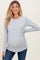 woman wearing a gray long sleeve maternity top with scalloped hem and baby bump visible