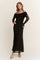 woman wearing a black off-the-shoulder evening gown with long sheer sleeves and a fitted silhouette
