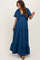 woman wearing a navy blue maternity maxi dress with short sleeves and a ruffled hem, showing her baby bump