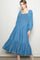 woman wearing a blue denim maxi dress with puff sleeves and a smocked bodice, standing against a neutral background