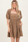 woman wearing a brown short puff sleeve dress with floral print and a square neckline, featuring pockets