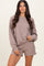 woman wearing a taupe oversized long sleeve sweatshirt and matching shorts