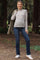 woman wearing a striped long sleeve maternity top with a round neckline and blue maternity jeans, standing outdoors