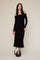 woman wearing a black off-the-shoulder ribbed maxi dress and black ankle boots