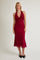 woman wearing a burgundy halter neck midi dress with a fitted silhouette and a flowy hemline