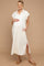 woman wearing a cream maternity dress with short sleeves, pockets, and side slits, cradling her baby bump