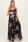 woman wearing a black floral maternity maxi dress and holding her baby bump