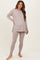 woman wearing a light taupe long sleeve maternity top and matching leggings, showing her baby bump