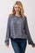 woman wearing a navy blue and white striped long sleeve sweatshirt with a relaxed fit and wide sleeves