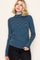 woman wearing a navy blue and white striped long sleeve top with a mock neck and slim fitstyle