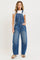 woman wearing a white t-shirt and blue denim overalls with side pockets and loose fit