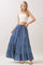 woman wearing a white ribbed crop top and a flowy denim tiered maxi skirt