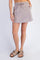 woman wearing a taupe casual mini skirt with an elastic waistband and side pockets, paired with brown sandals