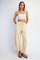 woman wearing a white crop top and yellow wide-leg pants with side pockets and drawstring waist