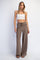 woman wearing a white cropped tank top and loose taupe knit wide-leg pants with front pockets