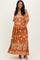 woman wearing a rust floral print maternity maxi dress and cradling her baby bump