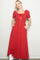 woman wearing a red maxi dress with puff sleeves and pockets, styled with white sneakers
