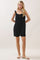 woman wearing a black striped sleeveless romper with ruffle straps and a tie front detail