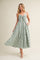woman wearing a green and white gingham maxi dress with a tie front and pockets