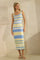 woman wearing a sleeveless midi dress with a wavy pattern in blue and yellow, styled with a headband and sandals