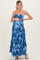 woman wearing a blue tie-dye maternity maxi dress with a fitted bodice and tiered skirt, showing her baby bump