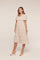 woman wearing a light beige floral midi dress with short puff sleeves and a fitted waist