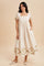 woman wearing a cream puff sleeve midi dress with floral embroidery at the hem and pockets