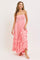 woman wearing a pink strapless maxi dress with tiered ruffles and a smocked bodice