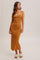 woman wearing a mustard ribbed maxi dress with a scoop neckline and decorative straps