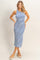 woman wearing a blue and white striped midi tank dress with a fitted silhouette and side slits, standing against a light background