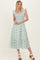woman wearing a square neckline floral midi dress with ruffle straps in light blue and green colors