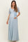 woman wearing a light blue lace maternity maxi dress with a bow accent and a visible baby bump