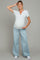 woman wearing a light gray maternity henley top and wide-leg jeans, showing her baby bump