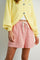 woman wearing a yellow cardigan and red and white striped shorts with an elastic waistband and drawstring