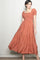 woman wearing a rust-colored maxi dress with puffed short sleeves and a tiered skirt design