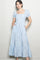 woman wearing a light blue puff sleeve midi dress with a smocked bodice and pockets