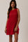 woman wearing a bright red sleeveless crochet dress with a relax fit and a side slit