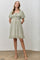 woman wearing a light green puff sleeve mini dress with a square neckline and ruffled hem