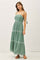 woman wearing a green maxi dress with spaghetti straps and embroidered details, standing pose