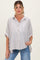 woman wearing a striped short sleeve maternity blouse with buttons, styled with rolled sleeves, paired with light wash jeans