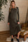 woman wearing a ribbed olive green long sleeve maternity dress with a side slit and a baby bump visible