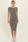 woman wearing a short sleeve olive green ribbed midi dress and white sneakers