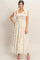 woman wearing a cream floral print maxi dress with tiered ruffles and tie shoulder straps